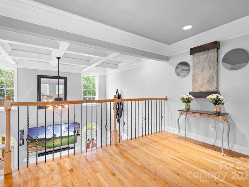 9112 Butterfly Court, Gastonia, NC 28056.  MLS# CAR4267047, YatesRealty ID 20271. Landing area of second floor overlooks the lovely Coffered Ceiling of Great Room.  Fountain Feature on wall conveys.