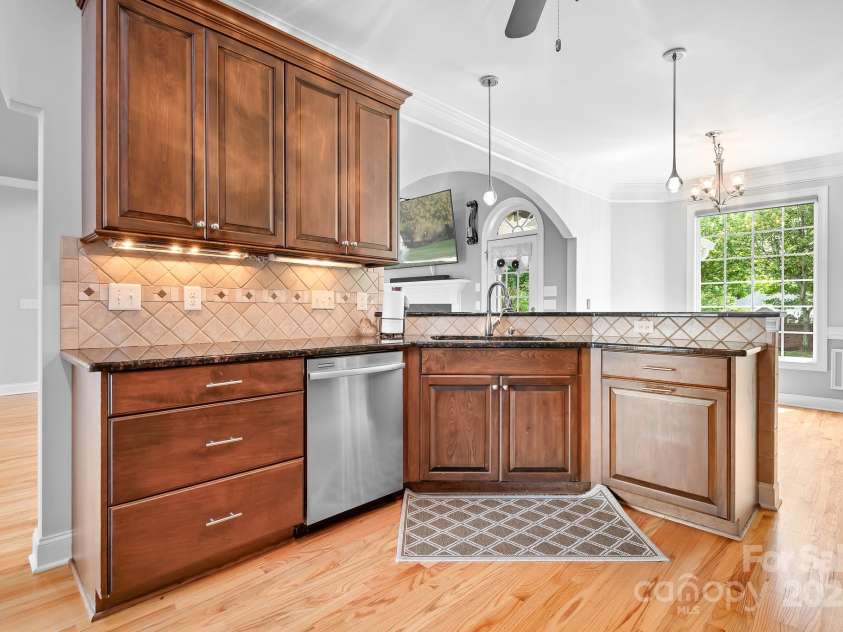 9112 Butterfly Court, Gastonia, NC 28056.  MLS# CAR4267047, YatesRealty ID 20271. Looking towards Breakfast Bar and Table Area.  Lovely under cabinet lighting.
