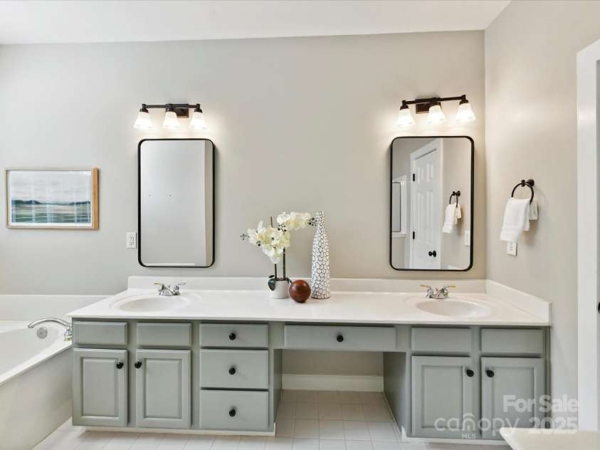 2215 Henery Tuckers Court, Charlotte, NC 28270.  MLS# CAR4267429, YatesRealty ID 20299. A spacious primary bath features dual vanities, a large tub, standup shower & separate water closet