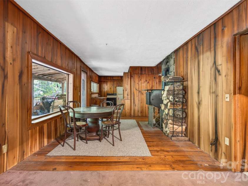 451 Signal Tree Road, Deep Gap, NC 28618.  MLS# CAR4374563, YatesRealty ID 20306. Open view from den into dining area and kitchen featuring a large window overlooking the covered front porch. 