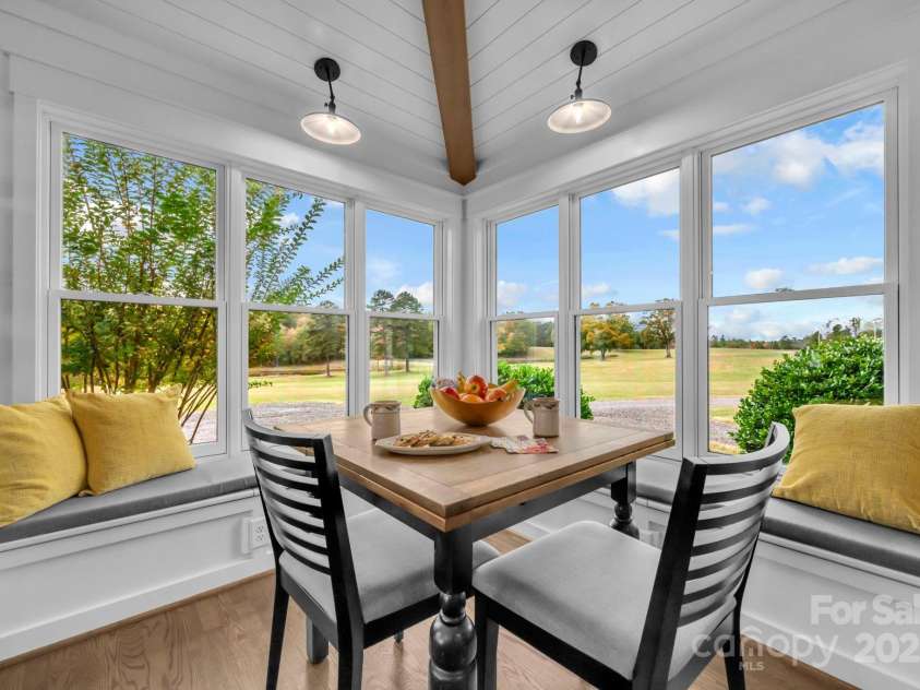 1260 Beaver Island Trail Road, Walnut Cove, NC 27052.  MLS# CAR4325171, YatesRealty ID 2036. Breakfast nook w/ shiplap ceiling and exposed beam, built-in bench storage, and wall of windows for pasture views