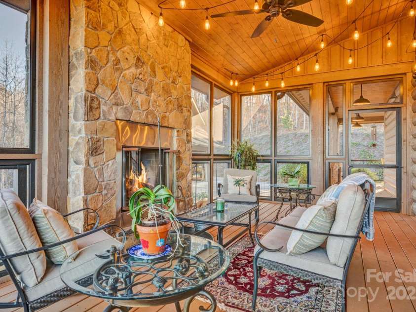 146 Sarinac Drive, Bostic, NC 28018.  MLS# CAR4327091, YatesRealty ID 2037. The side screen porch with rock wood burning fireplace is accessed from the Great Room