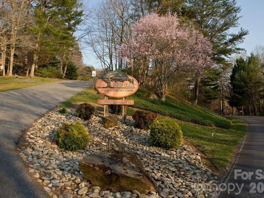 305 Piney Mountain Drive, Asheville, NC 28805.  MLS# CAR4351892, YatesRealty ID 20378. Main Entrance to the left - lower road to the pool and community