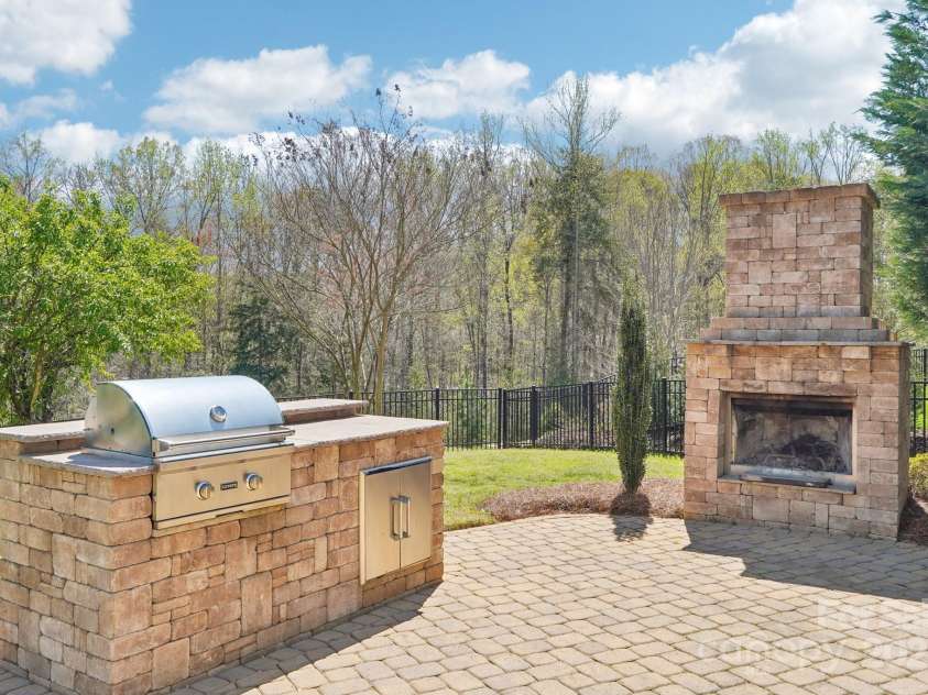 1034 Currituck Way, York, SC 29745.  MLS# CAR4239993, YatesRealty ID 20391. Outdoor fireplace with wooded view