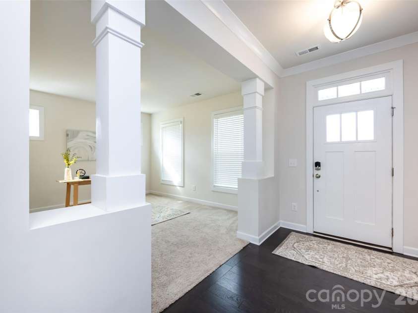 11440 Westbranch Parkway, Davidson, NC 28036.  MLS# CAR4366825, YatesRealty ID 20419. Bright and welcoming entryway featuring elegant columns, tray ceiling detail, and an open view into the main living space.