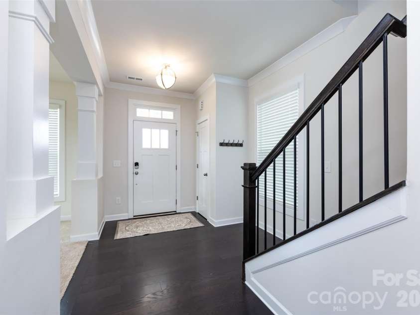 11440 Westbranch Parkway, Davidson, NC 28036.  MLS# CAR4366825, YatesRealty ID 20419. Bright and welcoming entryway featuring elegant columns, tray ceiling detail, and an open view into the main living space.