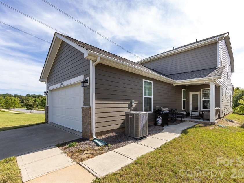 11440 Westbranch Parkway, Davidson, NC 28036.  MLS# CAR4366825, YatesRealty ID 20419. Private back exterior featuring a covered patio, low-maintenance yard, and attached two-car garage—perfect for relaxing or entertaining outdoors.