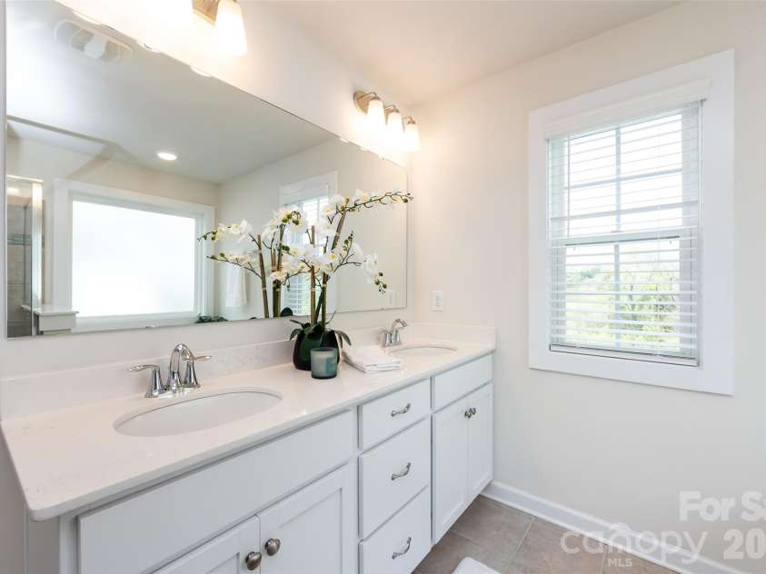 11440 Westbranch Parkway, Davidson, NC 28036.  MLS# CAR4366825, YatesRealty ID 20419. Spacious primary bath featuring dual vanities, a soaking tub, and a separate glass-enclosed shower for a spa-like retreat.