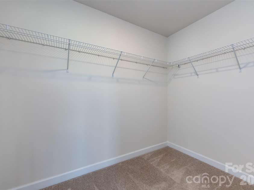 11440 Westbranch Parkway, Davidson, NC 28036.  MLS# CAR4366825, YatesRealty ID 20419. Spacious primary walk-in closet with ample shelving and hanging space for easy organization.