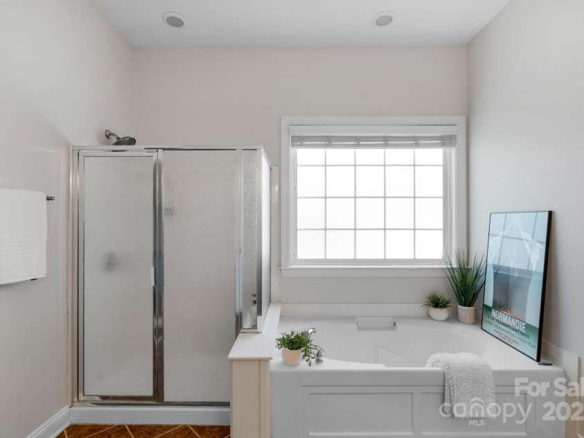 3017 Chisholm Court, Waxhaw, NC 28173.  MLS# CAR4234747, YatesRealty ID 20561. Serene and stylish primary bathroom with a soaking tub, modern recessed lighting, and a separate glass-enclosed shower