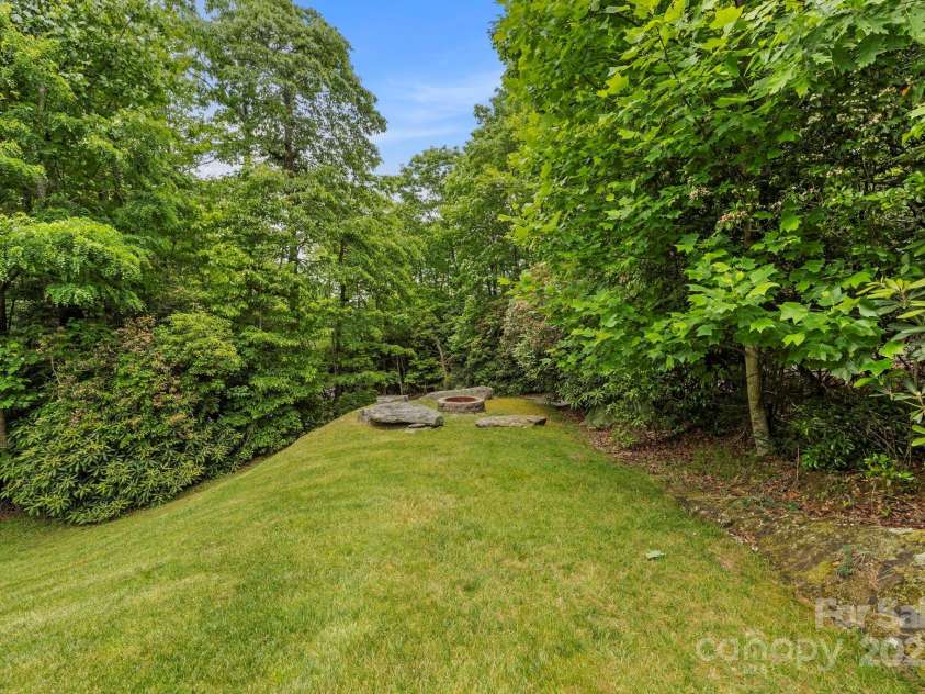 21 School House Road, Pisgah Forest, NC 28768.  MLS# CAR4262785, YatesRealty ID 20590. Firepit tucked in the corner for seclusion and privacy