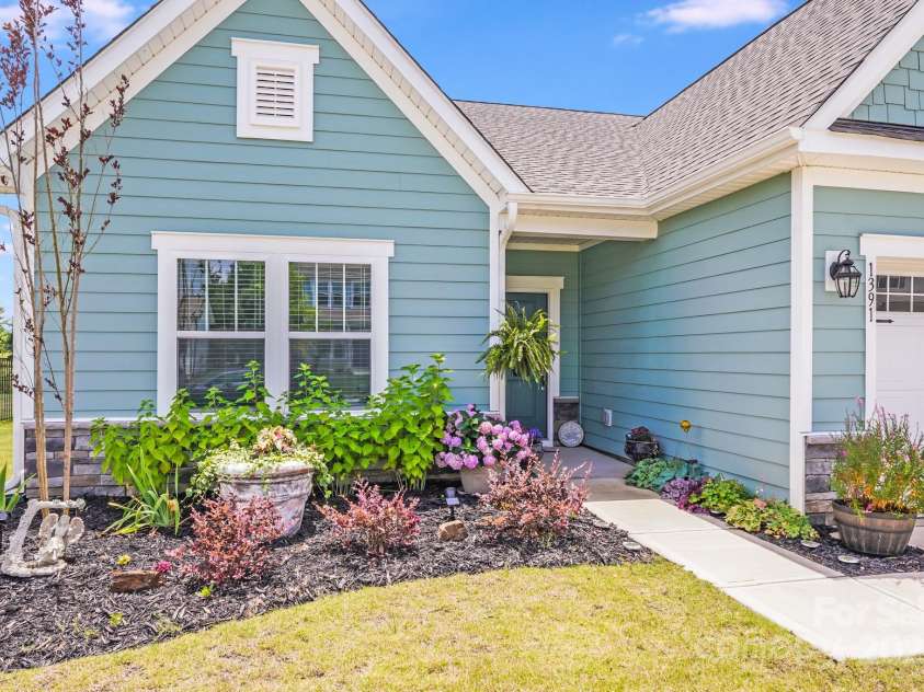 1391 Links Crossing Drive, Monroe, NC 28112.  MLS# CAR4270934, YatesRealty ID 20595. Beautifully landscaped beds in front of the home, featuring vibrant flowering plants that enhance curb appeal and create a welcoming first impression.