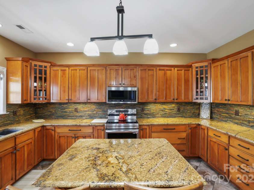 243 Wildbriar Road, Fletcher, NC 28732.  MLS# CAR4240300, YatesRealty ID 20721. Gourmet kitchen complete with custom cabinets, large island, granite countertops, beautiful backsplash, and ample counter space...PLUS...mountain views!