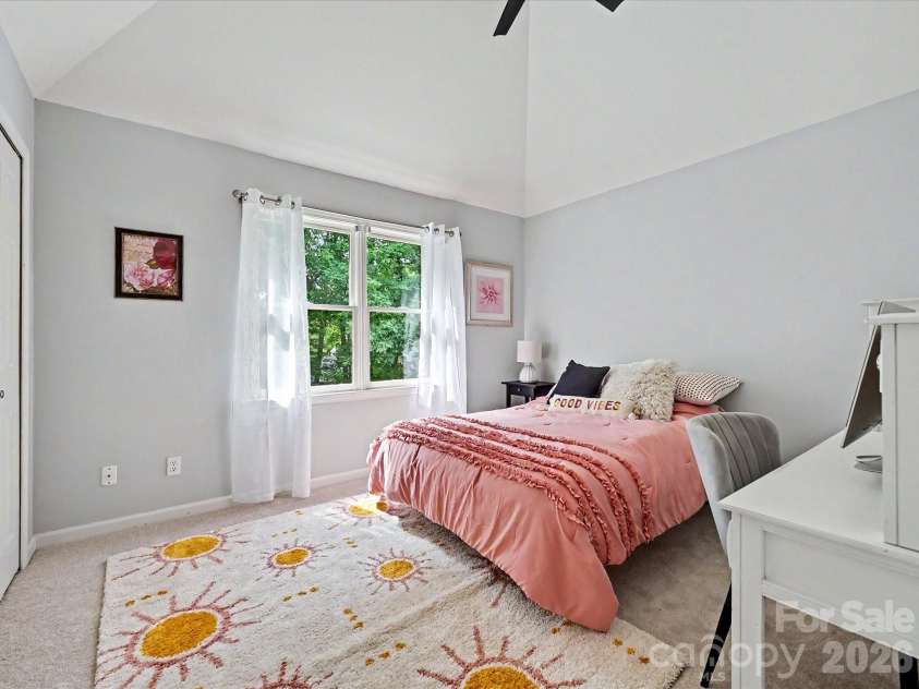 17405 Lynx Den Court, Davidson, NC 28036.  MLS# CAR4377973, YatesRealty ID 20726. Charming secondary bedroom with vaulted ceilings, soft natural light, and a cozy, inviting atmosphere perfect for guests or family.