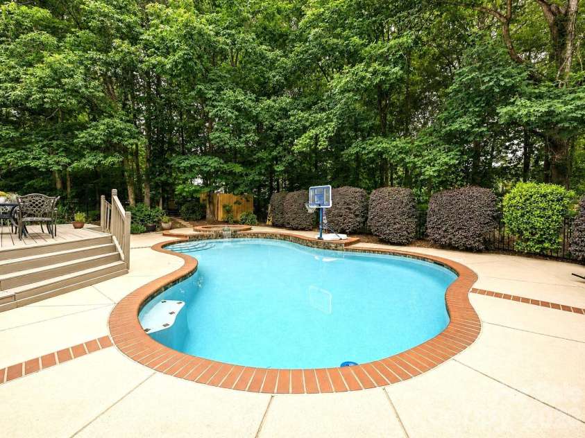 17405 Lynx Den Court, Davidson, NC 28036.  MLS# CAR4377973, YatesRealty ID 20726. Private backyard oasis featuring an in-ground pool, spacious patio, and lush tree-lined surroundings perfect for relaxing or entertaining.