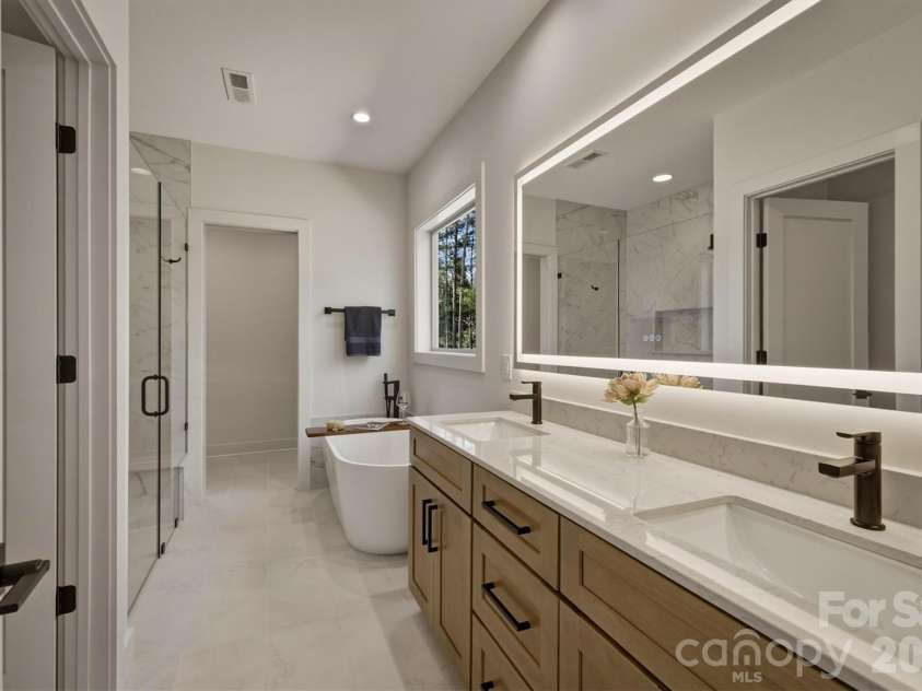 173 Waters Edge Drive, Nebo, NC 28761.  MLS# CAR4364596, YatesRealty ID 20742. ...and here is the owners' private bath. Features include a dual sink, drawer space and a huge lighted vanity mirror with an anti fog feature. Additionally, the bathroom is equipped with a Panasonic Whisper Quiet recessed