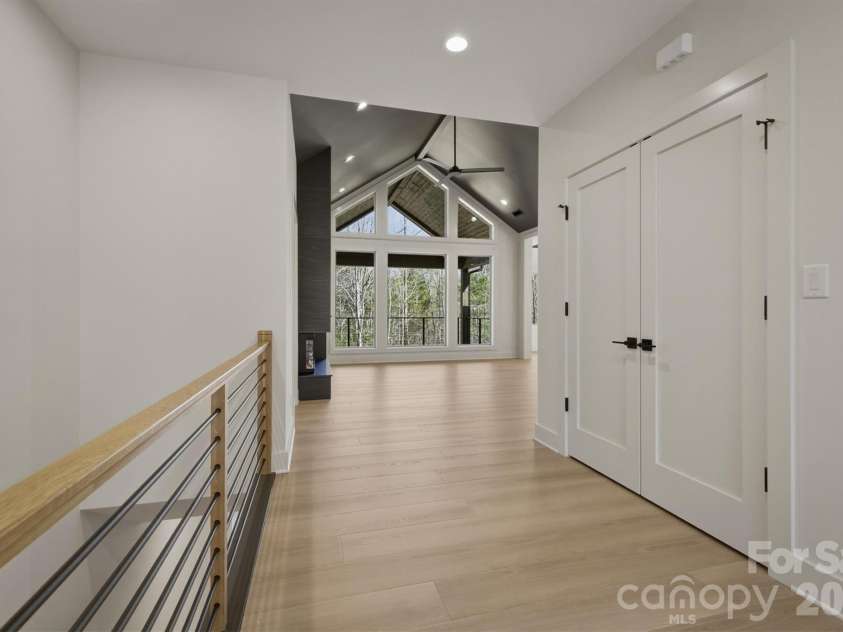 173 Waters Edge Drive, Nebo, NC 28761.  MLS# CAR4364596, YatesRealty ID 20742. From the front door, straight ahead you will walk past the horizontal contemporary railing and the large coat closet into the main living areas. There are beautiful sight lines through the living room out to the covered p