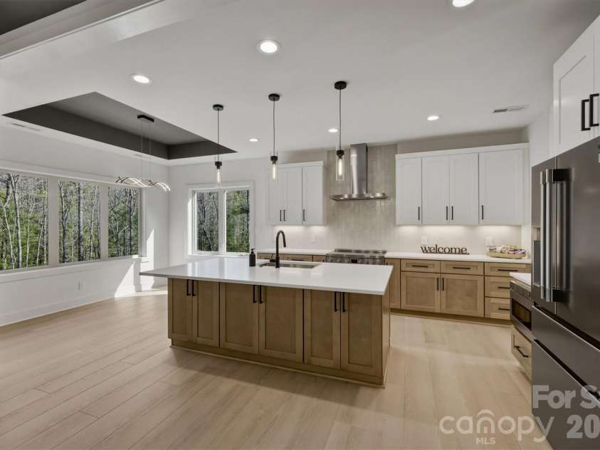 173 Waters Edge Drive, Nebo, NC 28761.  MLS# CAR4364596, YatesRealty ID 20742. From there our attention moves into the kitchen. Notice the pendant lights over the large island with room for bar stools and some under counter storage. 