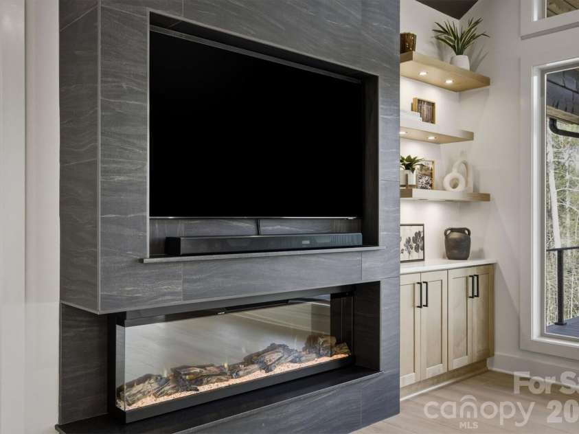 173 Waters Edge Drive, Nebo, NC 28761.  MLS# CAR4364596, YatesRealty ID 20742. Here is a closer look at the electronics. In the back corner, you will discover the built in cabinetry with lighted floating wood shelves. You will notice that the rooms are all well equipped with convenient storage oppor