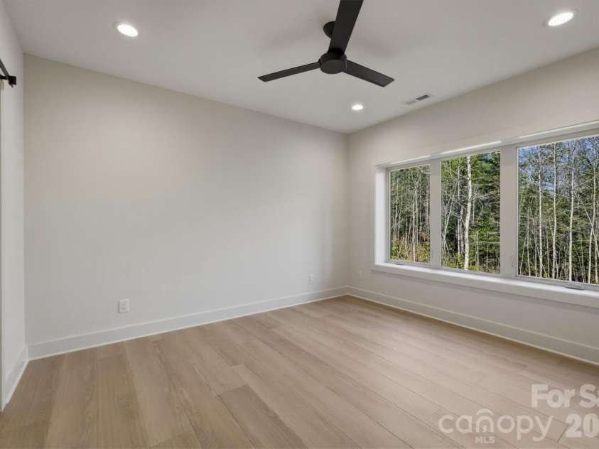 173 Waters Edge Drive, Nebo, NC 28761.  MLS# CAR4364596, YatesRealty ID 20742. On the left side of the lower level is found Bedroom Suite #4. This bedroom features a Minka-Aire ceiling fan and a 