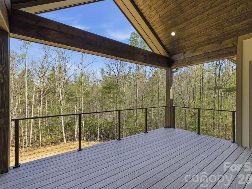 173 Waters Edge Drive, Nebo, NC 28761.  MLS# CAR4364596, YatesRealty ID 20742. Once on the deck, the views will capture your attention, but the cathedral ceiling and the open triangle on the end of the house accentuate the experience. There is also recessed lighting and horizontal railings. The floo
