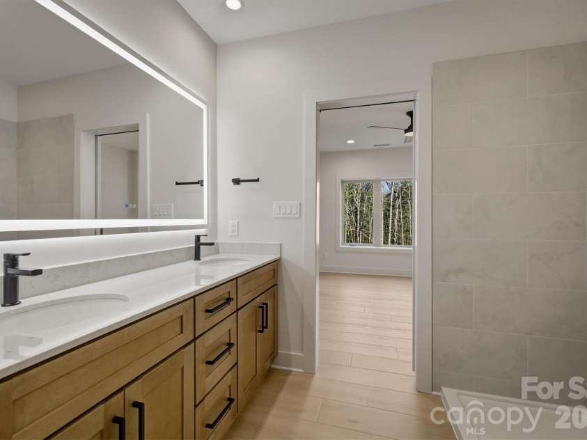 173 Waters Edge Drive, Nebo, NC 28761.  MLS# CAR4364596, YatesRealty ID 20742. The dual sinks have the same lovely black contemporary bathroom fixtures just like the rest of the house and the same gorgeous high quality, soft close wood cabinets that are throughout.