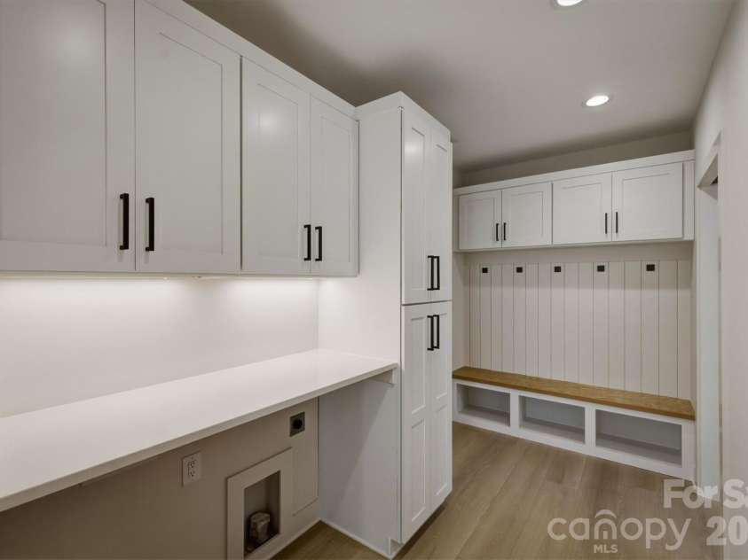 173 Waters Edge Drive, Nebo, NC 28761.  MLS# CAR4364596, YatesRealty ID 20742. The laundry room is elevated by having a quartz counter top with space for a washer/dryer underneath. The laundry area is located between the walk-in pantry and the door that leads into the 2 car garage. There is a dropzo