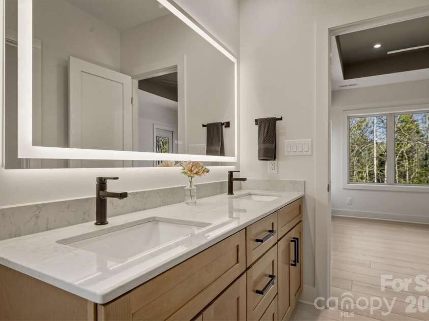 173 Waters Edge Drive, Nebo, NC 28761.  MLS# CAR4364596, YatesRealty ID 20742. The lighted mirror over the double sink vanity can be dimmed, brightened and the color can be changed. There is another button that gently heats the mirror to prevent fog. There is technology hidden everywhere in this hom