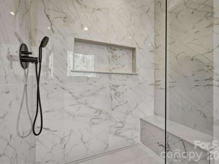 173 Waters Edge Drive, Nebo, NC 28761.  MLS# CAR4364596, YatesRealty ID 20742. The luxurious zero entry walk-in shower is fabulous and is custom tiled with an upgraded custom frameless glass shower wall, niche and bench.