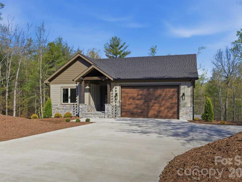 173 Waters Edge Drive, Nebo, NC 28761.  MLS# CAR4364596, YatesRealty ID 20742. The oversized concrete driveway offers ample parking for guests with a 20'x20' auxiliary parking area. The Clopay Modern Steel Ultra Grain garage door is powered by a LiftMaster 