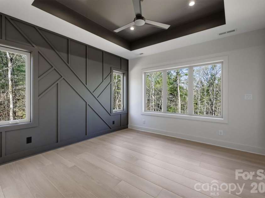 173 Waters Edge Drive, Nebo, NC 28761.  MLS# CAR4364596, YatesRealty ID 20742. The owners' suite has a magnificent feature wall. There is a Minka-Aire ceiling fan and a exquisite tray ceiling, and of course, lots of large windows to let the natural light inside.