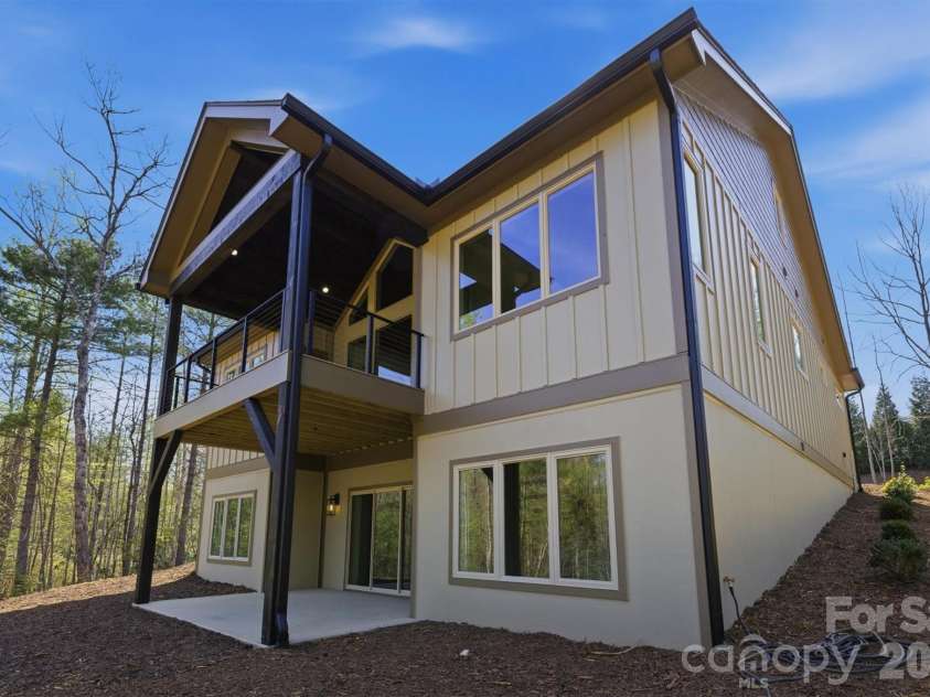 173 Waters Edge Drive, Nebo, NC 28761.  MLS# CAR4364596, YatesRealty ID 20742. The rear elevation showcases the main level covered deck with its vaulted ceiling and the walk-out level patio for outdoor living areas from both levels of the home. The windows are Jeld-Wen Premium Vinyl windows, and the