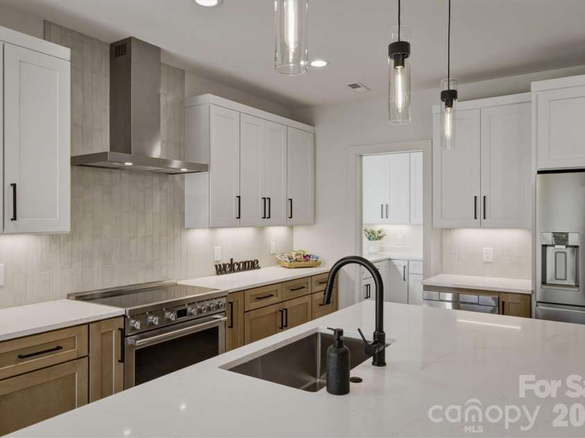 173 Waters Edge Drive, Nebo, NC 28761.  MLS# CAR4364596, YatesRealty ID 20742. This gourmet kitchen features quartz countertops, syllish cabinetry, tiled backspash, and a Frigidaire professional appliance package that includes a 36