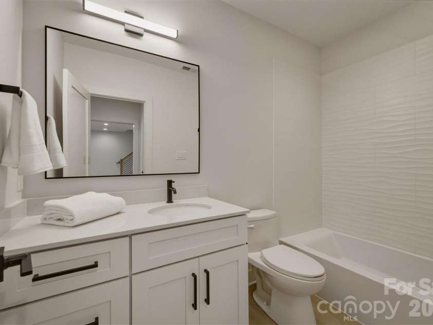 173 Waters Edge Drive, Nebo, NC 28761.  MLS# CAR4364596, YatesRealty ID 20742. This third bathroom features an acrylic tub with custom tiled walls.