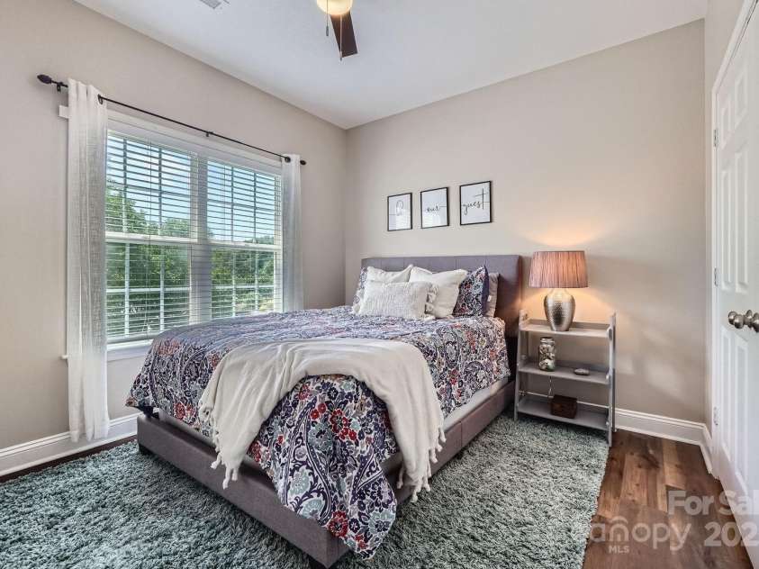 113 Dairy Farm Road, Mooresville, NC 28115.  MLS# CAR4262731, YatesRealty ID 20820. This bright and inviting bedroom offers a cozy retreat with soft natural light streaming through the large window. Neutral walls and rich vinyl plank flooring create a warm, timeless backdrop. Whether used as a guest