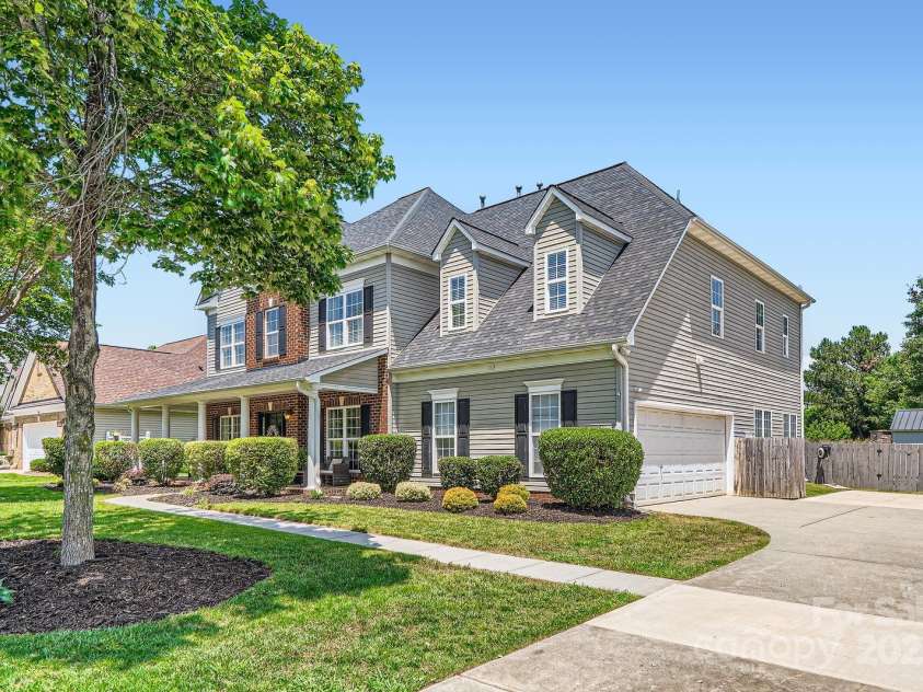 113 Dairy Farm Road, Mooresville, NC 28115.  MLS# CAR4262731, YatesRealty ID 20820. This home features a spacious side-load 2-car garage, blending seamlessly with the home's classic façade and enhancing its curb appeal. The extended driveway offers ample parking space for guests or additional vehicl