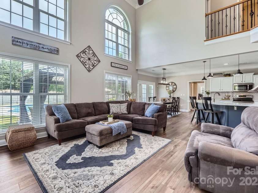 113 Dairy Farm Road, Mooresville, NC 28115.  MLS# CAR4262731, YatesRealty ID 20820. This inviting family room is the heart of the home, featuring soaring two-story ceilings and expansive windows that flood the space with natural light.