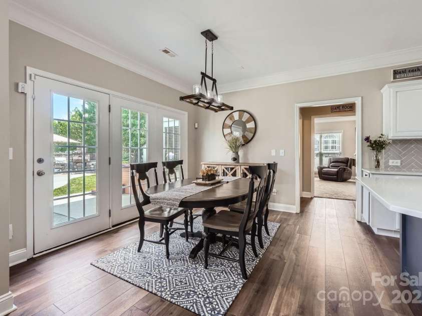 113 Dairy Farm Road, Mooresville, NC 28115.  MLS# CAR4262731, YatesRealty ID 20820. This light-filled dining area offers a perfect blend of casual elegance and functionality. French doors open to the backyard oasis, creating an effortless indoor-outdoor flow ideal for entertaining. Rich luxury vinyl