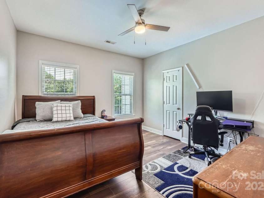 113 Dairy Farm Road, Mooresville, NC 28115.  MLS# CAR4262731, YatesRealty ID 20820. Tucked quietly at the back of the home, this spacious secondary bedroom offers privacy, natural light, and modern functionality. Two large windows overlook the backyard, creating a serene setting for rest or focus. T