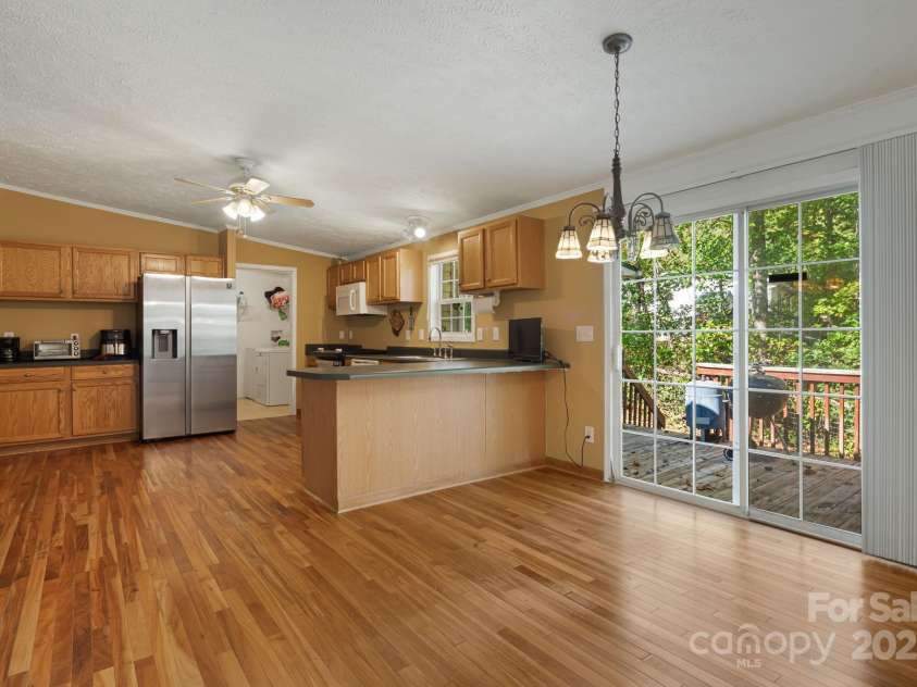 35 Evelyn Acres Drive, Asheville, NC 28806.  MLS# CAR4312401, YatesRealty ID 20886. Sliding glass door opens to the back deck. Note the laundry room off the kitchen and the counter bar.