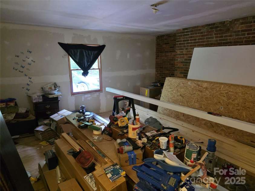 244 Mcmahan Lane, Bakersville, NC 28705.  MLS# CAR4269540, YatesRealty ID 20927. Another angle of the primary bedroom - note brick wall from back of living room fireplace