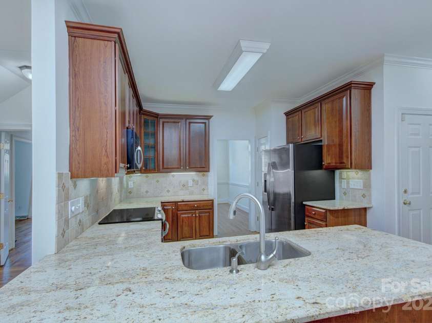 8044 Hawk Crest Court, Charlotte, NC 28270.  MLS# CAR4267919, YatesRealty ID 20940. Kitchen with granite counters, 2 pantry spaces, tile backsplash
