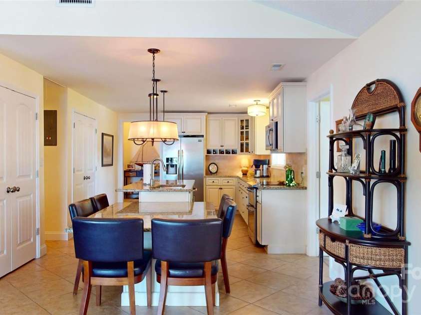 114 Caraway Lane, Mooresville, NC 28117.  MLS# CAR4268740, YatesRealty ID 20994. Built-in dining table for 6 plus additional seating at kitchen island.