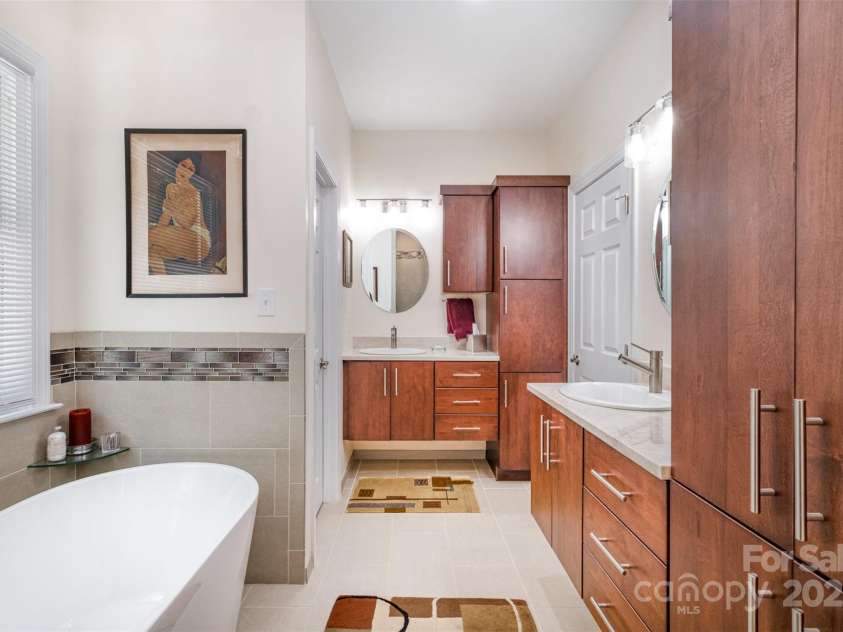 345 Beaten Path Road, Mooresville, NC 28117.  MLS# CAR4269577, YatesRealty ID 21006. Newly renovated primary bathroom with custom cabinets with built in laundry basket and linen storage, separate sinks and large walk in shower