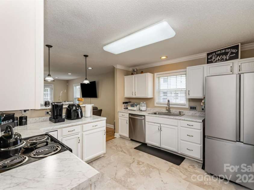 2040 Brantley Creek Drive, Kannapolis, NC 28083.  MLS# CAR4286622, YatesRealty ID 21011. The kitchen features some nice updates, including a newer microwave, white cabinets, and countertops.