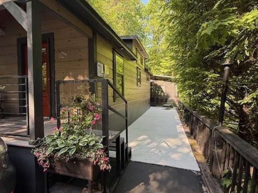 26 Cumberland Drive, Lake Toxaway, NC 28747.  MLS# CAR4262953, YatesRealty ID 21021. Side view to the back porch area and back of home