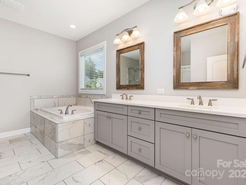 8709 Raven Top Drive, Mint Hill, NC 28227.  MLS# CAR4263622, YatesRealty ID 21023. Luxurious primary ensuite with soaking tub & dual vanities