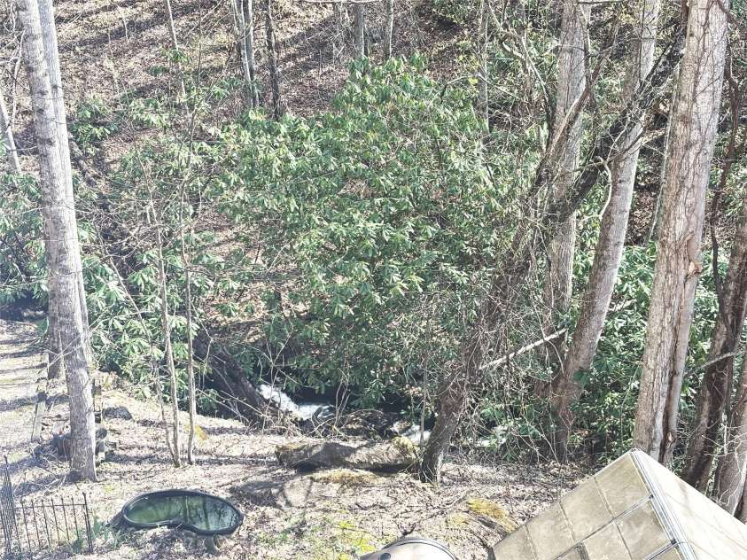 97 Hughes Drive, Maggie Valley, NC 28751.  MLS# CAR4239722, YatesRealty ID 21040. You can enjoy this natural creek in the property.