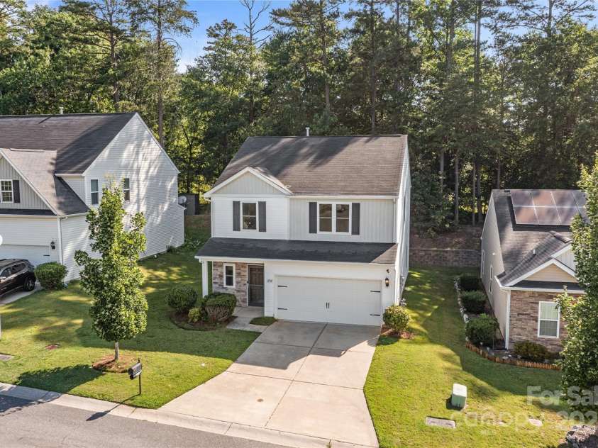 2532 Blue Moss Drive, Dallas, NC 28034.  MLS# CAR4271917, YatesRealty ID 21069. Great curb appeal with backdrop of towering trees. Easy-maintenance vinyl siding with stacked stone trim.