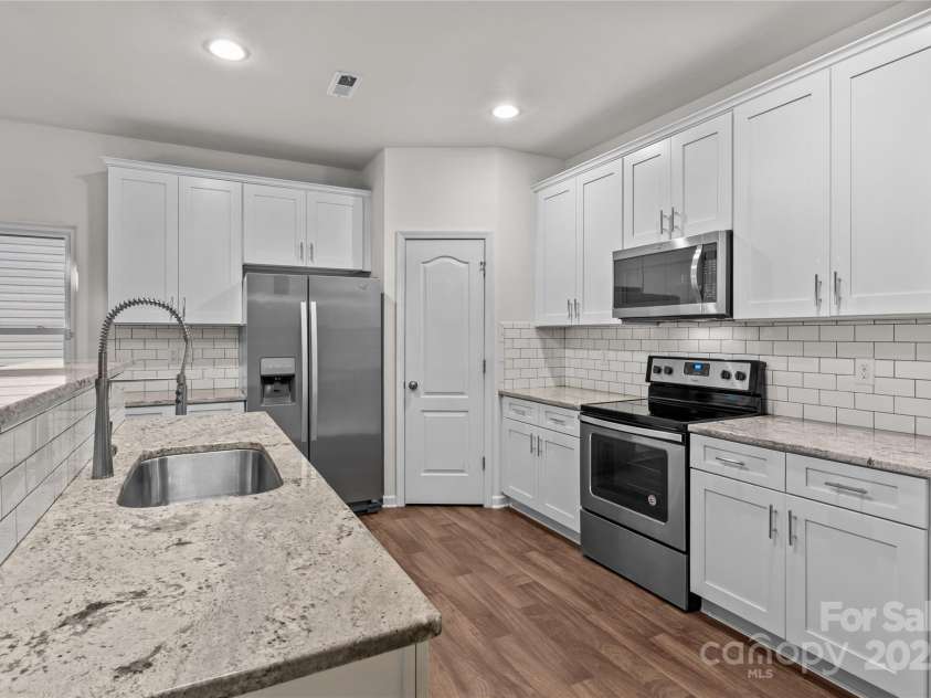 2532 Blue Moss Drive, Dallas, NC 28034.  MLS# CAR4271917, YatesRealty ID 21069. Kitchen features Level-3 granite counters, LVP flooring, recessed lights, good sized pantry.